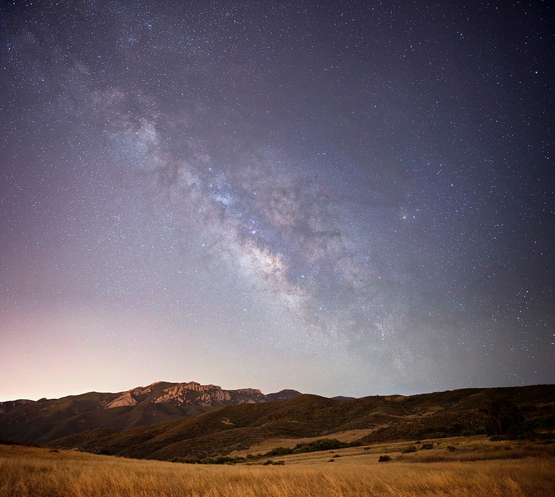 The Milky Way over a dark mountain horizon